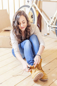 Portrait of young woman sitting on bed at home