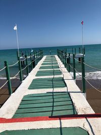 Pier on sea against clear sky