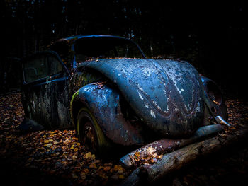 Abandoned vintage car at night