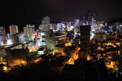 Illuminated cityscape against sky at night