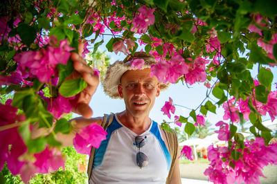 45-50 year old man of athletic build with a backpack in hurgada egypt covered with pink flowers