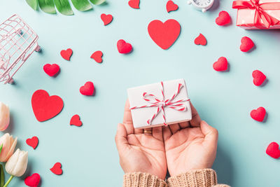 Cropped hand of woman holding christmas decorations on table