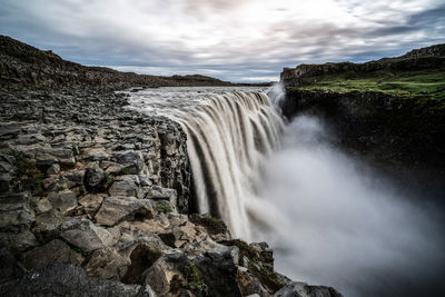 Scenic view of waterfall against sky