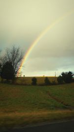 Scenic view of grassy field against cloudy sky