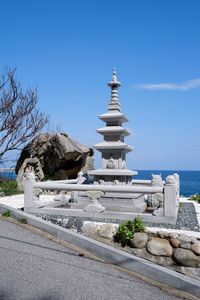 View of building by sea against clear blue sky