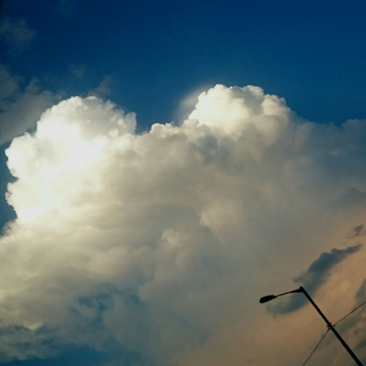 low angle view, sky, cloud - sky, beauty in nature, blue, cloud, tranquility, cloudy, scenics, sky only, nature, cloudscape, tranquil scene, sunbeam, sunlight, outdoors, sun, idyllic, no people, day