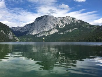 Scenic view of lake by mountains against sky