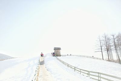 Snow covered landscape against clear sky