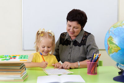 Portrait of smiling family sitting on table