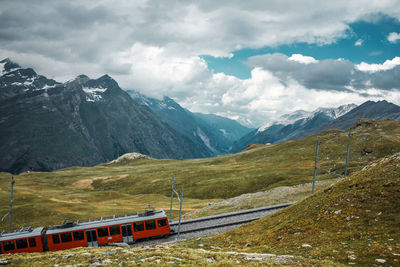 Railway and red train in gornergrat mountains. zermatt, swiss alps. adventure in switzerland.