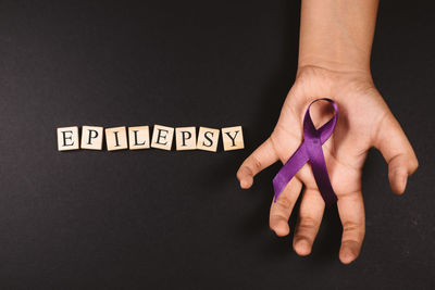 Close-up of woman hand with text against black background