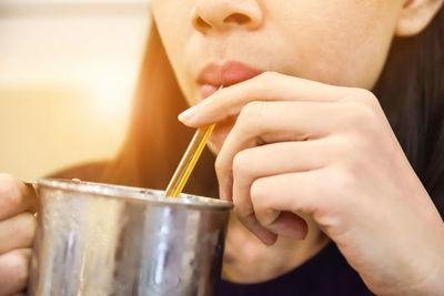 Midsection of woman drinking with straw