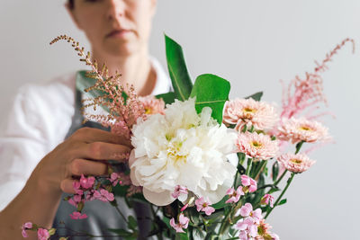 A flower boutique employee creates a flower arrangement.