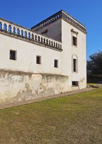 Low angle view of old building against clear blue sky