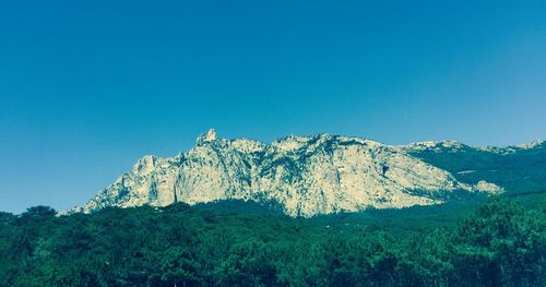 Low angle view of mountain against blue sky