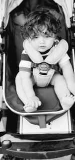 Cute baby boy sitting in carriage