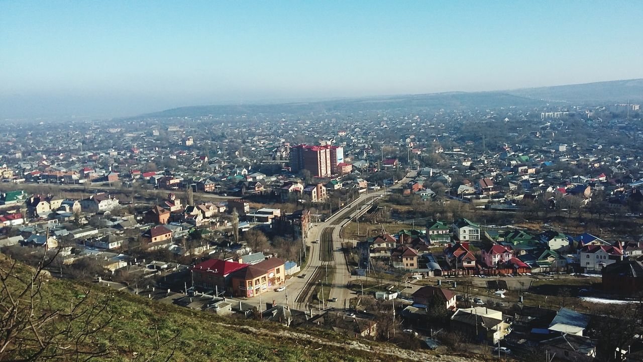 clear sky, building exterior, cityscape, city, architecture, built structure, copy space, crowded, high angle view, residential district, residential building, residential structure, mountain, city life, landscape, community, outdoors, town, house, sky