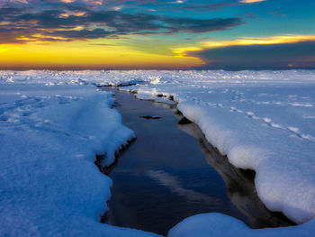 Scenic view of frozen sea against sky during sunset