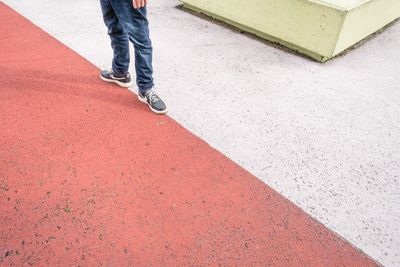 Low section of man standing on road