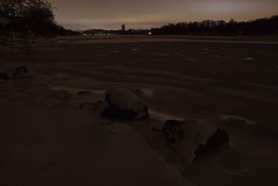 Scenic view of frozen landscape against sky at sunset