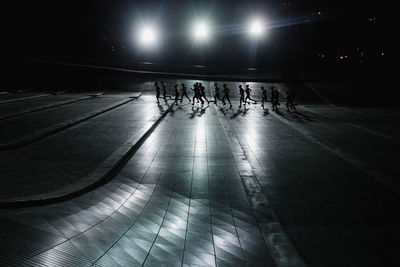 People walking in illuminated corridor