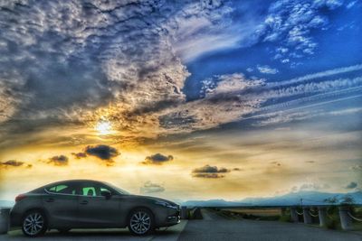 Car on road against sky during sunset