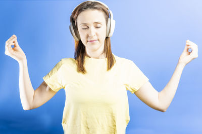 Young woman standing against blue sky