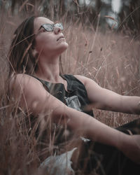 Side view of young woman looking away on field