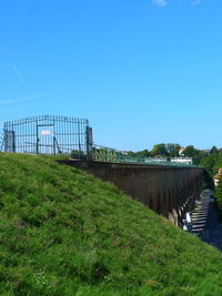 Bridge on field against clear blue sky