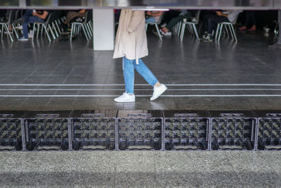 Low section of woman standing on seat