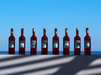 Row of bottles on table against blue background