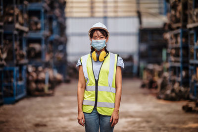 Portrait of man wearing hat standing at construction site