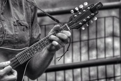 Close-up mid section of a man playing guitar