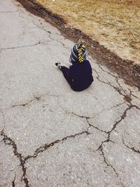 High angle view of man sitting on footpath