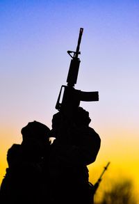 Low angle view of silhouette crane against clear sky during sunset