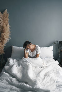 High angle view of woman sitting on bed at home