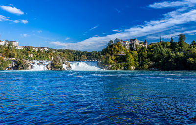 Scenic view of lake rhinefalls switzerland against cloudy sky