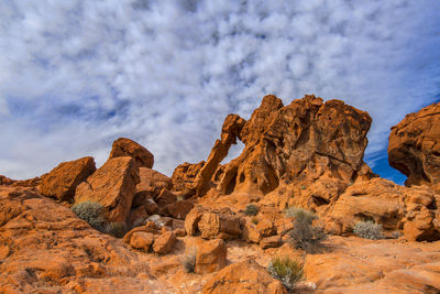 Low angle view of rock formations against cloudy sky