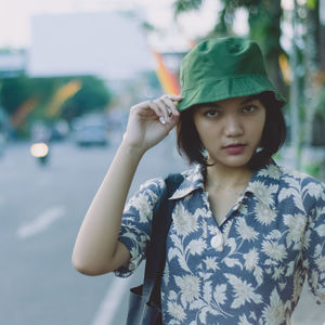 Portrait of beautiful young woman standing against blurred background