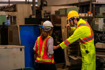 Engineers and technicians are inspecting the operation of large machines in the factory.