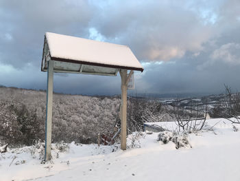 Built structure on snow covered field against sky