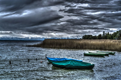 Boat moored in lake against sky