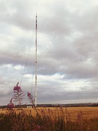 Electricity pylon on field against sky