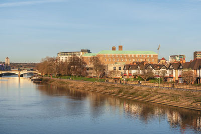 Bridge over river against buildings in city