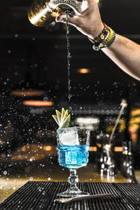 Midsection of man pouring wine in glass