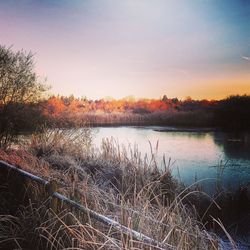 Scenic view of lake against sky at sunset