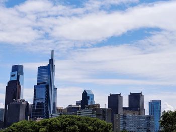 Buildings in city against cloudy sky