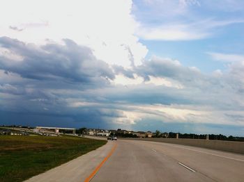 View of country road against cloudy sky