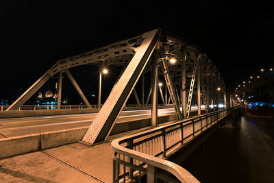 Illuminated suspension bridge against sky at night