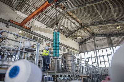 Man working with spools in factory